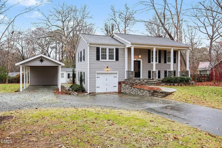 Photo of a grey split-level house with a front porch